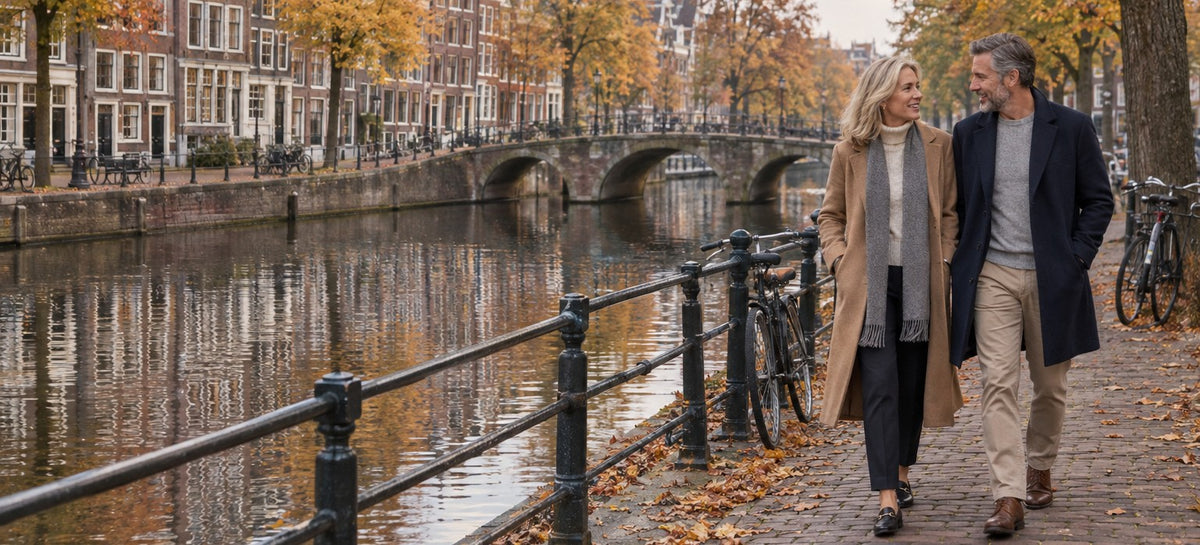 Stel wandelt in de herfst langs een Amsterdamse gracht